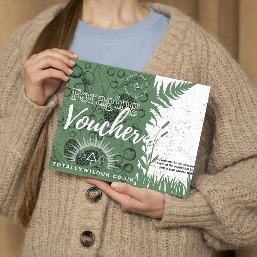 lady holding foraging voucher in front of chest with jumper